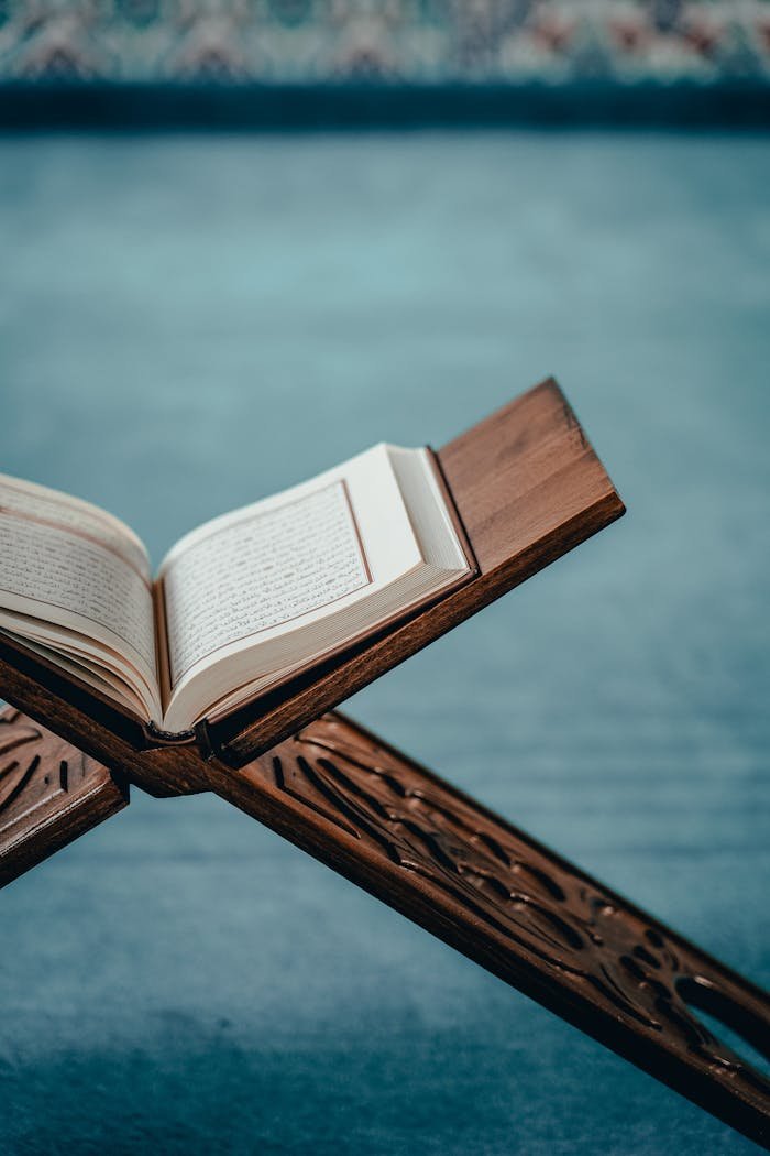 An open Quran displayed on an intricately designed wooden stand, evoking spiritual tranquility.